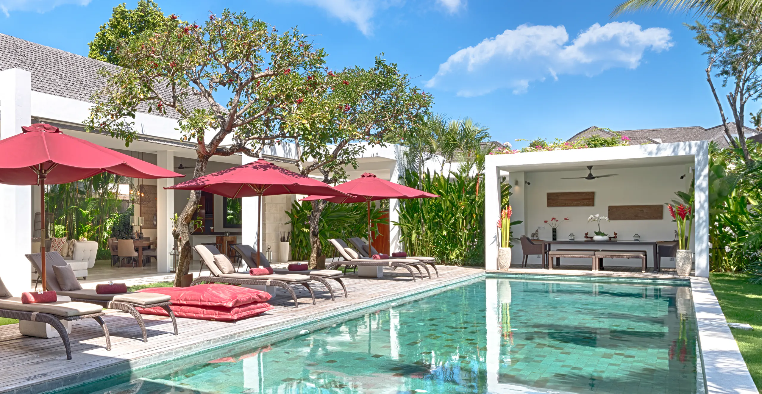 The long greenstone pool at Casa Brio, claret parasols and loungers down the ironwood deck and the balé at the far end