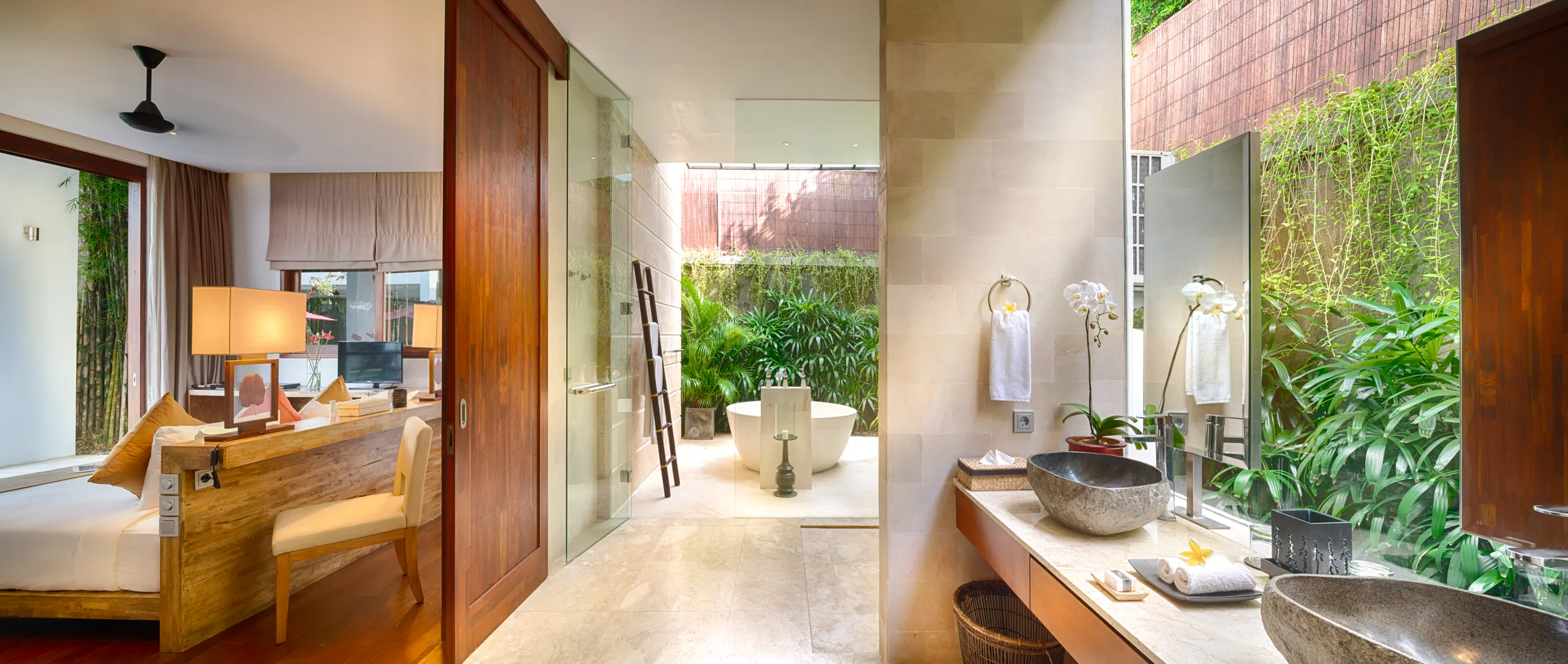 The Master Suite I bathroom at Casa Brio, twin stone basins on a timber vanity with the round bath in its open-air courtyard beyond