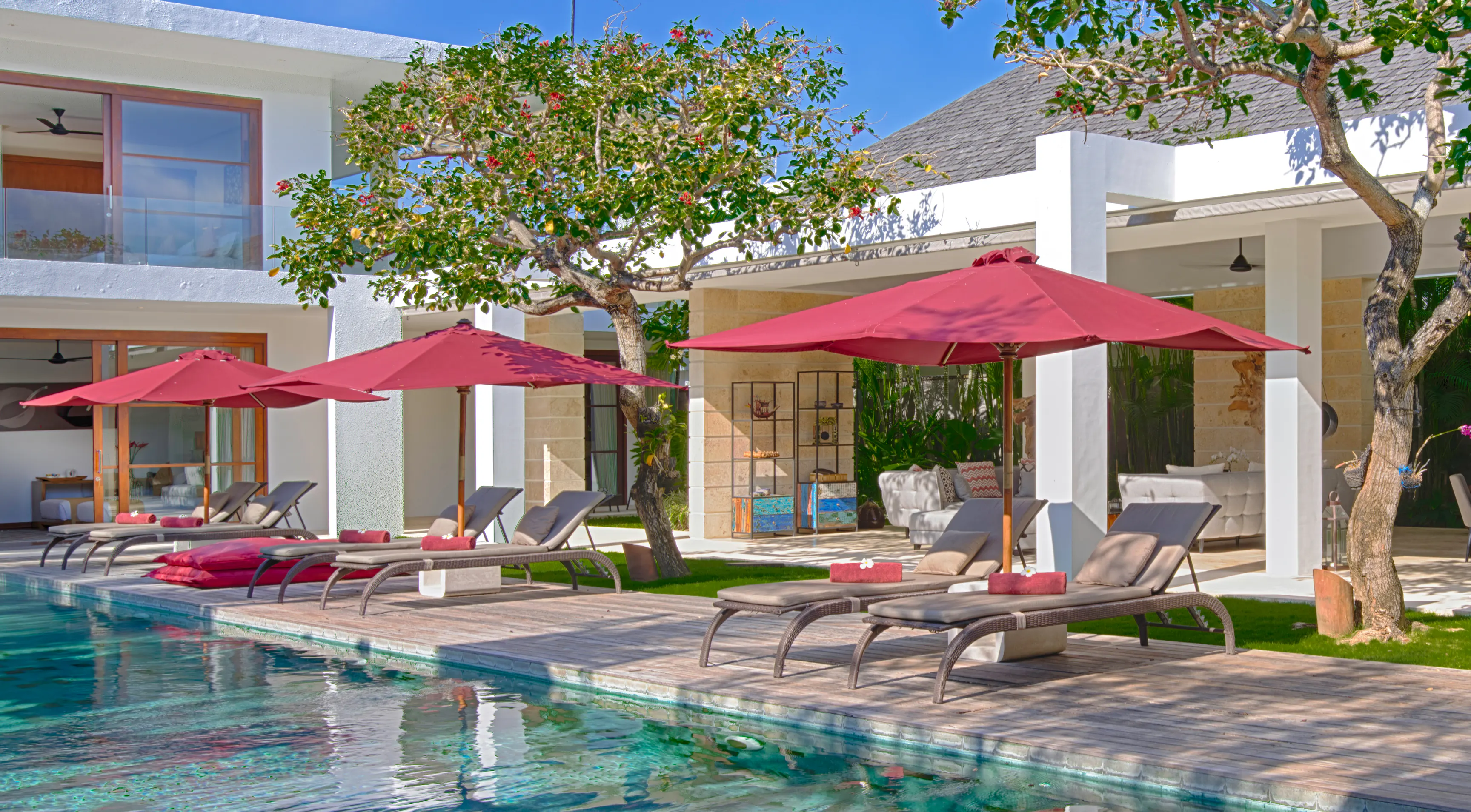 Sun loungers and crimson parasols along the ironwood pool deck